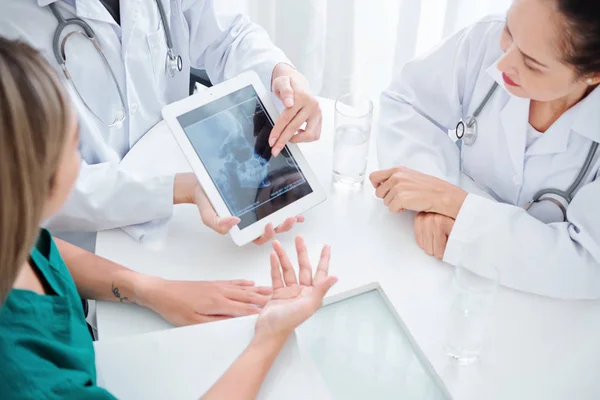 환자의 엑스레이를 토론하고 진단과 처리를 정의하기 위하여 테이블에 신경학자의 — 스톡 사진