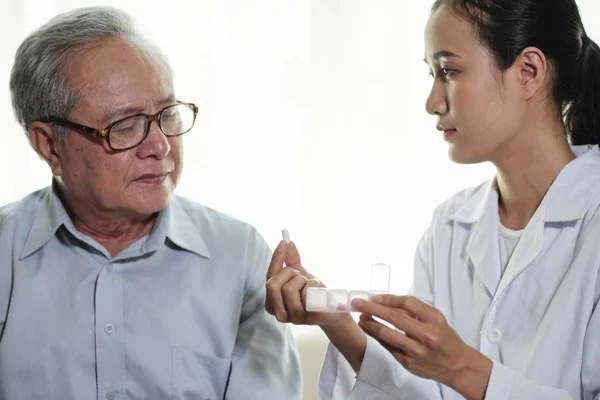 Aziatische Jonge Vrouwelijke Arts Houden Pillen Uitleggen Aan Haar Senior — Stockfoto