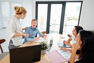 İş ekibi, yönetim kurulu odasında ki toplantıda belgeler ve dizüstü bilgisayar la masada oturur ve planlama çalışmaları ile birlikte çalışır.