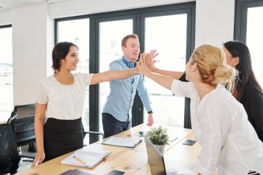 Başarılı iş ekibi ayakta ve birbirlerine yüksek bir beş veren onlar ofiste iş toplantısından sonra başarı kutluyor