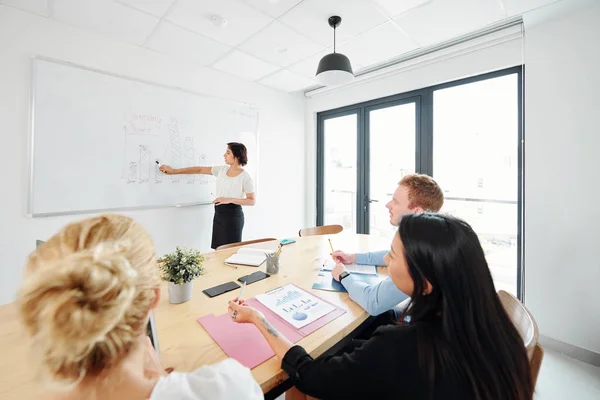 Joven Empresaria Apuntando Pizarra Blanca Presentando Informe Negocios Para Equipo — Foto de Stock