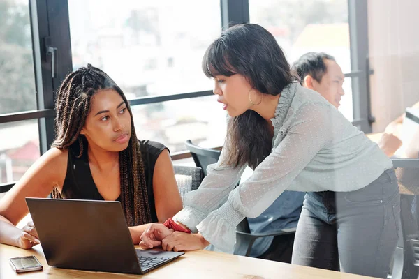 Junge Geschäftsfrau Steht Und Erklärt Ihrer Kollegin Die Büro Sitzt — Stockfoto