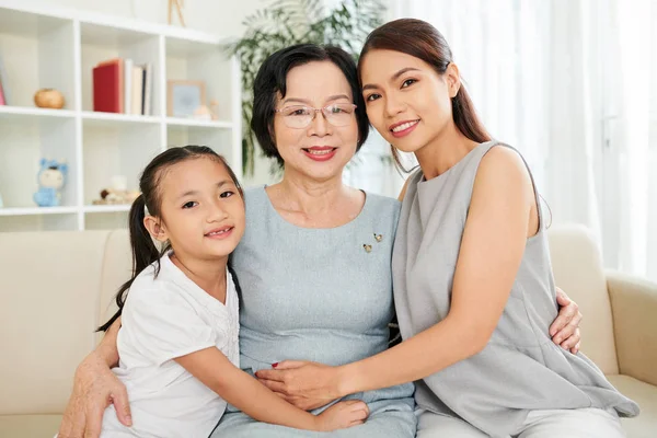 幸福的亚洲家庭一代母亲女儿和祖母拥抱和微笑的镜头 而休息在沙发上的肖像 — 图库照片