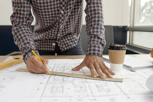 年轻工程师用尺子勾选衬衫的特写镜头 在办公室用铅笔绘制新建筑或房屋的蓝图 — 图库照片