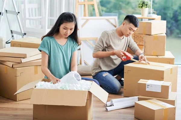 Aziatische Jonge Vrouw Uitpakken Kartonnen Doos Met Dingen Terwijl Haar — Stockfoto