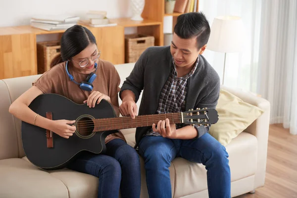 Asiático Joven Mostrando Novia Cómo Tocar Guitarra Mientras Sientan Sofá —  Fotos de Stock