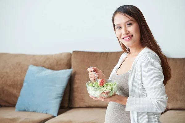 自宅で新鮮なおいしいサラダのボウルを食べる笑顔のかわいいアジアの女性の肖像画 — ストック写真