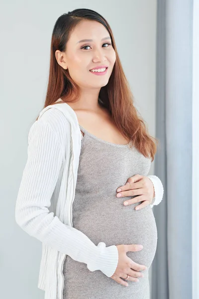 彼女の大きな腹に触れ カメラを見て若い美しい妊娠中のベトナムの女性のトリミング画像 — ストック写真