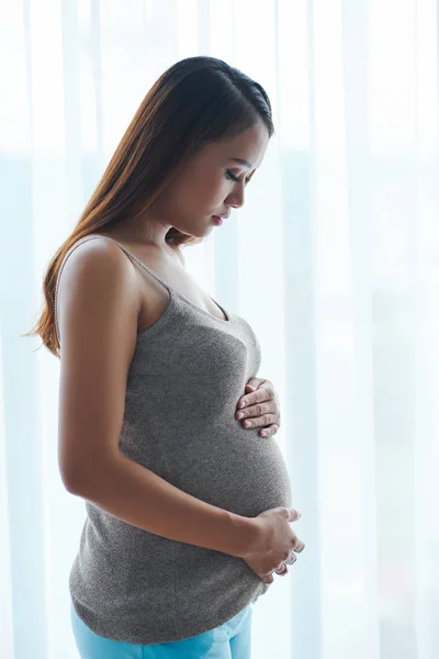 Calma Joven Vietnamita Embarazada Pie Contra Ventana Tocando Vientre — Foto de Stock