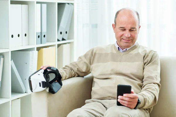 Smiling Mature Man Sitting Sofa Watching Tutorial Smartphone Using Virtual — Stock Photo, Image