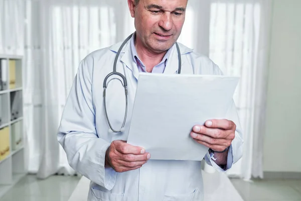 Médico Frunciendo Ceño Abrigo Blanco Leyendo Historia Clínica Del Paciente — Foto de Stock