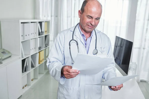 Médico General Serio Frunciendo Ceño Leyendo Documento Con Los Resultados — Foto de Stock