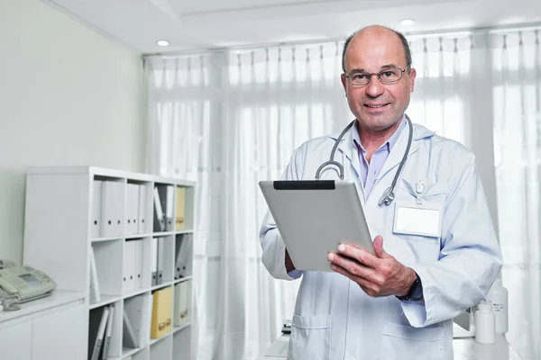 Portrait Smiling Mature General Practitioner Glasses Holding Tablet Computer Looking — Stock Photo, Image