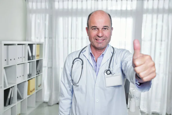 Portret Szczęśliwego Dojrzałego Lekarza Odznaką Jego Delikatny Edukacja Pokazując Kciuki — Zdjęcie stockowe