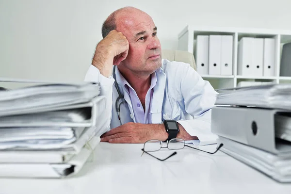 Mature General Practitioner Sitting His Table Piled Binders Documents Daydreaming — Stock Photo, Image