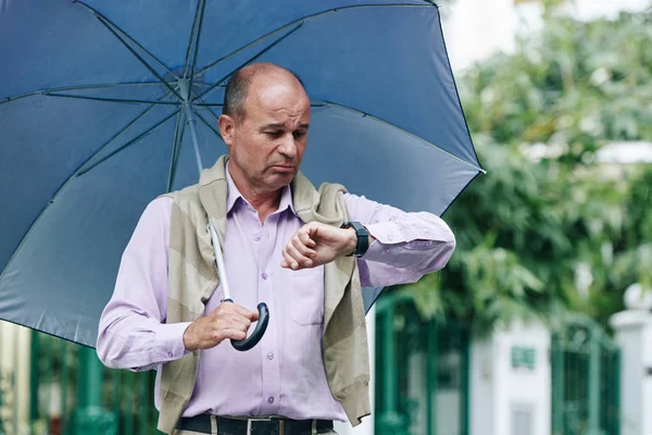 Gefrustreerd Opdrinkende Volwassen Man Met Paraplu Controletijd Zijn Horloge Hij — Stockfoto
