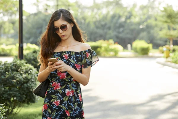 Серьезная Молодая Женщина Солнечных Очках Ходит Улице Проверяет Свои Соцсети — стоковое фото