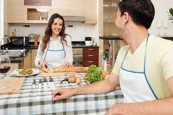 Jonge Mooie Lachende Vrouw Snijden Frans Stokbrood Voor Het Diner — Stockfoto