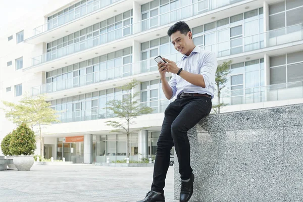 Sonriente Joven Empresario Asiático Sentado Aire Libre Comprobar Los Mensajes — Foto de Stock