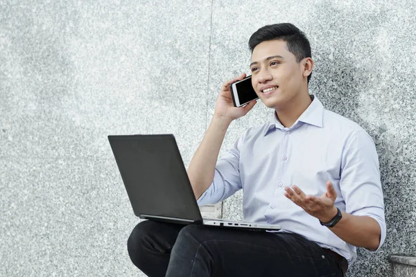 Çalışana telefon görüşmesi yaparken dizüstü gesturing ile Genç Vietnamlı girişimci