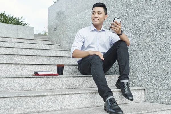 Sorrindo Jovem Empresário Vietnamita Sentado Passos Com Smartphone Mãos Refrigerante — Fotografia de Stock