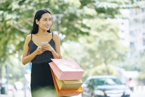 亚洲年轻女子 长黑头发 穿着漂亮的西装 拿着手机的纸购物袋 在城市户外度过她的时间 — 图库照片