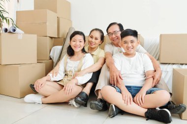 Mutlu çocuklar ve dedesi etrafında birçok karton kutular ile yeni evin oturma odasında katta oturan