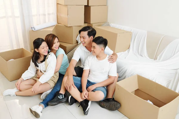 Happy Parents Hugging Teenage Kids Resting Floor New Apartment Moving — Stock Photo, Image