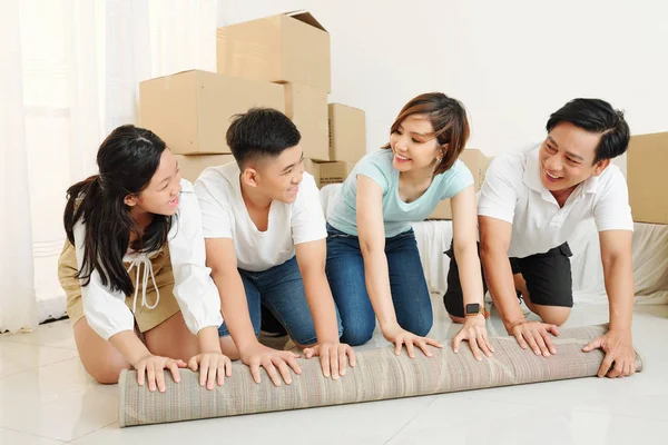 Felice Famiglia Asiatica Quattro Tappeto Svolgimento Guardando Altro Con Sorrisi — Foto Stock