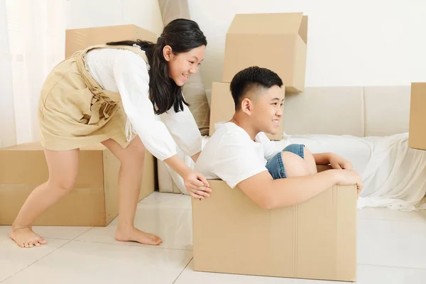 Cheerful Excited Girl Pushing Cardboard Box Her Brother Sitting Playing — Stock Photo, Image