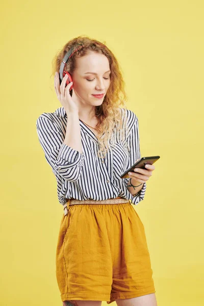 Vacker Ung Lockig Kvinna Bär Hörlurar När Lyssnar Musik Smartphone — Stockfoto