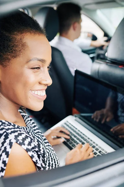 Šťastná Africká Žena Pracující Notebooku Při Jízdě Autě Jako Cestující — Stock fotografie
