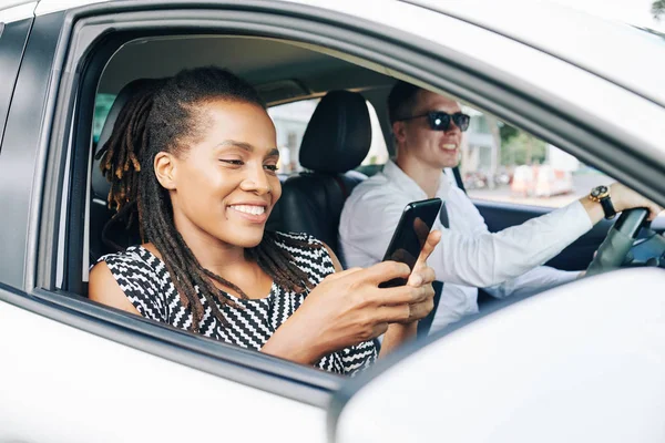 Afričanky Mladá Žena Čtení Zprávy Mobilním Telefonu Usmívá Při Jízdě — Stock fotografie