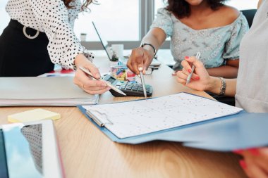 Belgeye mali tablo ve satış istatistikleri ile bakan iş kadınlarının elleri