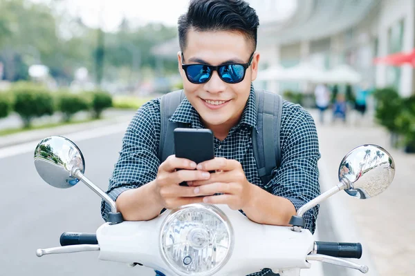 Joven Vietnamita Positivo Sentado Scooter Jugando Adictivo Juego Teléfono Inteligente —  Fotos de Stock