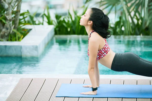 アジアの健康な女性は彼女の目を閉じて リゾートで屋外プールの近くの運動マットでリラックス — ストック写真
