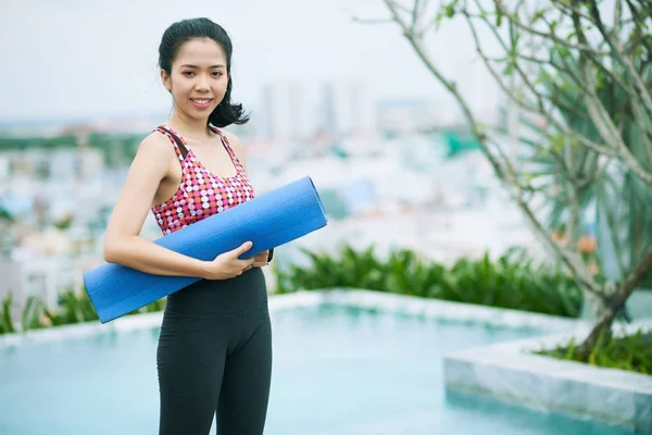 亚洲女运动员的形象 站在室外等待训练时 带着运动垫对着摄像机微笑 — 图库照片