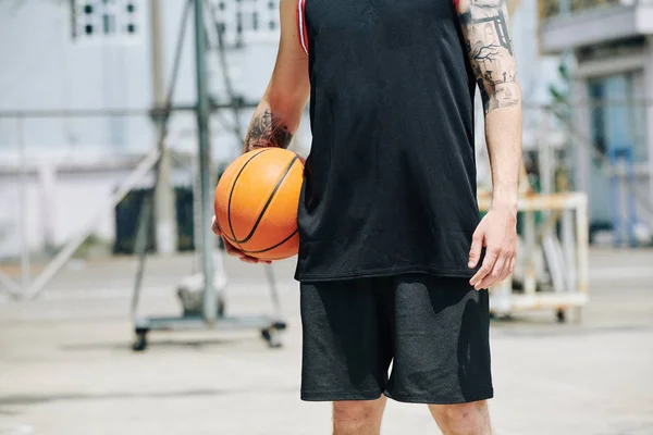 暑い夏の日にボールと屋外に立ってフィット背の高いバスケットボール選手のトリミングされた画像 — ストック写真