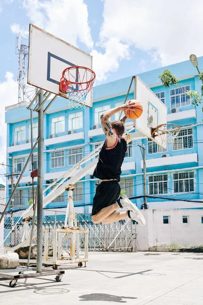 Баскетболист Форме Прыгает Высоко Бросить Мяч Корзину Играет Улице — стоковое фото