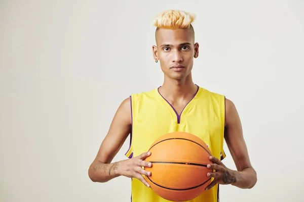 Portret Poważnego Młodego Sportowca Żółtym Mundurze Pozującego Studio Piłką Koszykówki — Zdjęcie stockowe