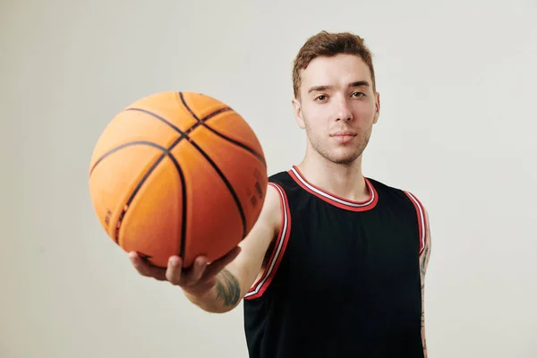 Yakışıklı Ciddi Beyaz Bir Basketbolcu Kolunu Topa Uzatıp Kameraya Bakıyor — Stok fotoğraf