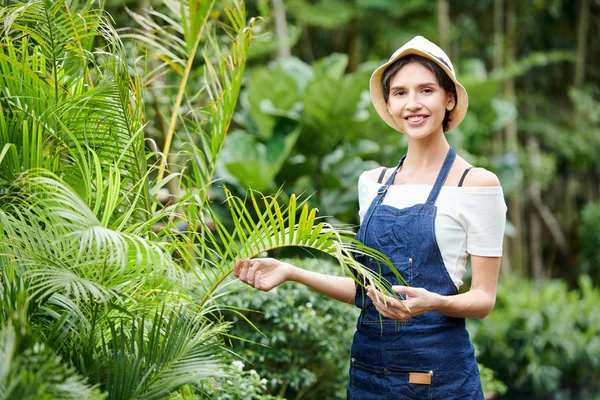 熱帯の庭で働くことを楽しむかなり笑顔の若い女性の肖像画 — ストック写真