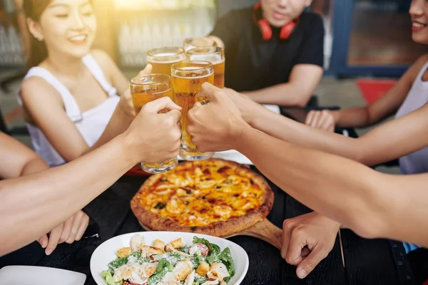 Grupo Amigos Sentados Mesa Con Ensalada Pizza Tostadas Con Vasos —  Fotos de Stock