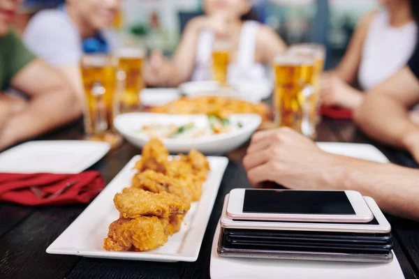 Tallrik Med Mat Hög Med Mobiltelefoner Folk Vid Bordet — Stockfoto