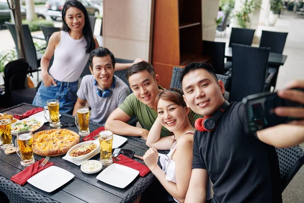 Asyalı Genç Adam Restorandaki Buluşmaları Sırasında Arkadaşlarıyla Cep Telefonuyla Selfie — Stok fotoğraf