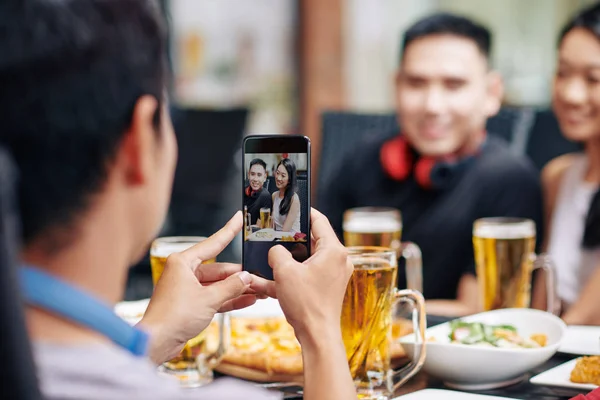 Zadní Pohled Mladého Muže Jak Fotí Své Přátele Mobilním Telefonu — Stock fotografie