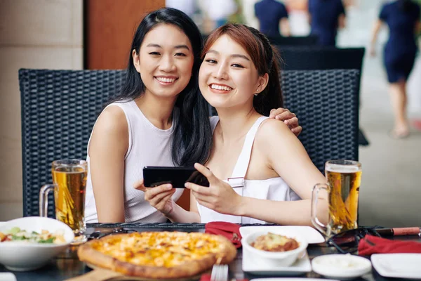 Portrait Two Asian Women Embracing Smiling Camera While Using Mobile — Stock Photo, Image