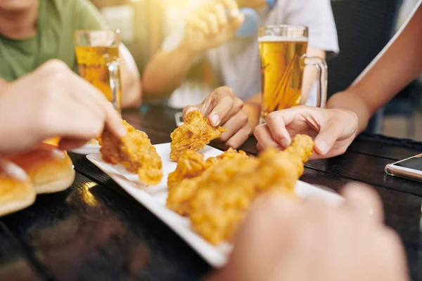 Close Pessoas Sentadas Mesa Comendo Fast Food Bebendo Cerveja Durante — Fotografia de Stock