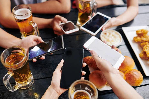 Close Friends Using Mobile Phones Table While Drinking Beer Together — Stock Photo, Image