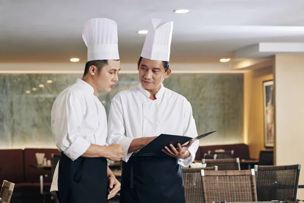 Zwei Asiatische Kollegen Uniform Zeigen Auf Speisekarte Und Unterhalten Sich — Stockfoto